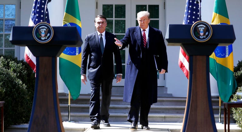 President Donald Trump and Brazilian President Jair Bolsonaro walk out to the Rose Garden at the White House for a news conference, Tuesday, March 19, 2019, in Washington. President Donald Trump and Brazilian President Jair Bolsonaro