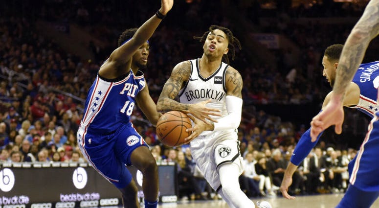 Brooklyn Nets' D'Angelo Russell, center right, drives to the basket as Philadelphia 76ers' Shake Milton defends during the first half of an NBA basketball game, Thursday, March 28, 2019, in Philadelphia. Brooklyn Nets' D'Angelo Russell, center right, drives to the basket as Philadelphia 76ers' Shake Milton defends during the first half of an NBA basketball game.
