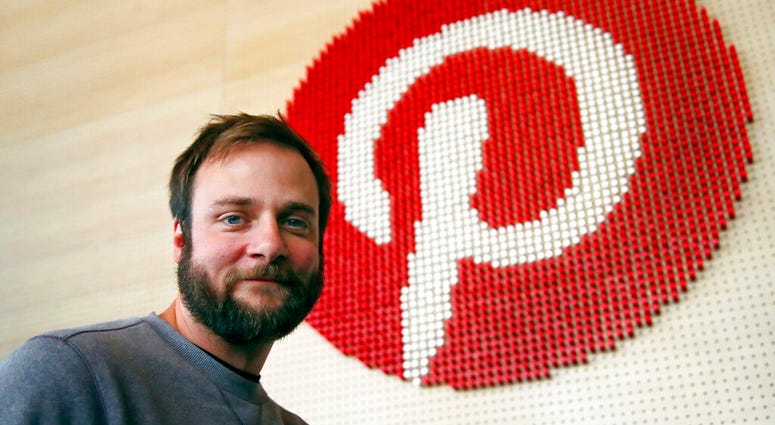 In this Oct. 11, 2018, file photo, Evan Sharp, Pinterest co-founder and chief product officer, poses for a photo beside a wall of pegs symbolizing the company logo at Pinterest headquarters in San Francisco. Evan Sharp, Pinterest co-founder and chief product officer