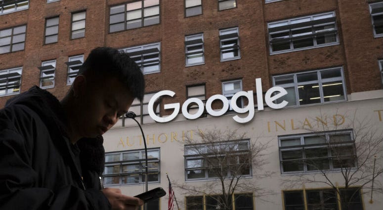 FILE - In this Dec. 17, 2018, file photo, a man using a mobile phone walks past Google offices in New York. Executives from Google and Facebook are facing Congress Tuesday, April 8, 2019, to answer questions about their role in the hate crimes and the ris A man using a mobile phone walks past Google offices in New York. Executives from Google and Facebook are facing Congress Tuesday, April 8, 2019, to answer questions about their role in the hate crimes and the ris