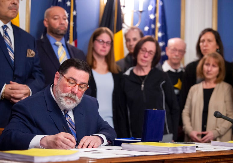 Pittsburgh Mayor Bill Peduto, surrounded by supporters and family members of Tree of Life synagogue shooting victims, signs three gun-control bills into law, Tuesday, April 9, 2019, at the City-County Building in downtown Pittsburgh. Pittsburgh Mayor Bill Peduto