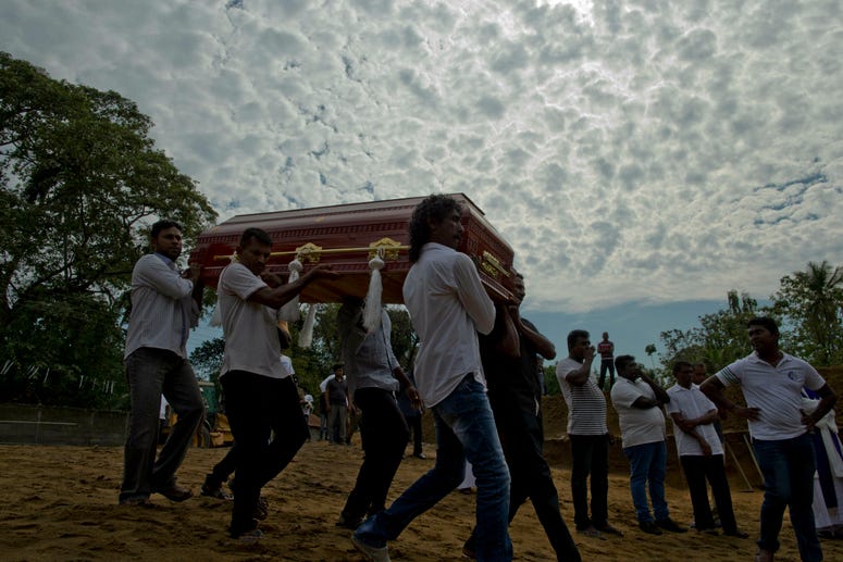 Relatives carry a coffin for burial during a mass burial for Easter Sunday bomb blast victims in Negombo, Sri Lanka, Wednesday, April 24, 2019. A mass burial for victims in Sri Lanka.