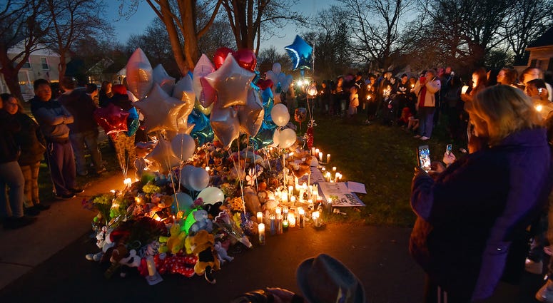 In this Wednesday, April 24, 2019 photo, community members in Crystal lake, Ill. hold a vigil in memory of 5-year-old Andrew "AJ" Freund. Andrew "AJ" Freund vigil