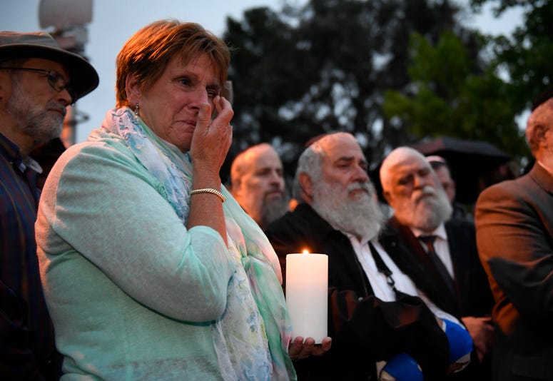 A woman cries during a candlelight vigil held for victims of the Chabad of Poway synagogue shooting, Sunday, April 28, 2019, in Poway, Calif. Poway, California synagogue shooting