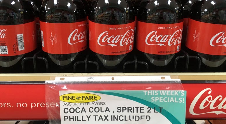 In this July 18, 2018, file photo, a sweetened beverage tax sign is posted by bottles of drinks at a supermarket in the Port Richmond neighborhood of Philadelphia. A sweetened beverage tax sign.