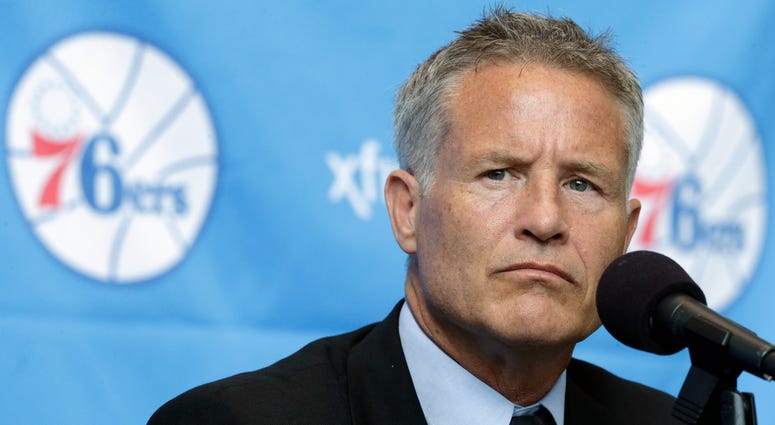 In this Aug. 14, 2013 file photo Philadelphia 76ers head coach Brett Brown listens during a news conference in Philadelphia. Brett Brown