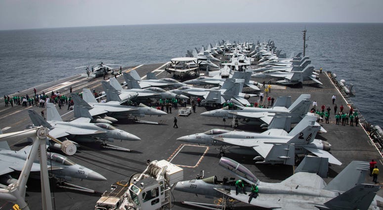 In this Sunday, May 19, 2019, photo released by the U.S. Navy, sailors partake in a foreign object and debris walk-down on the flight deck of the Nimitz-class aircraft carrier USS Abraham Lincoln in the Arabian Sea. U.S. Navy