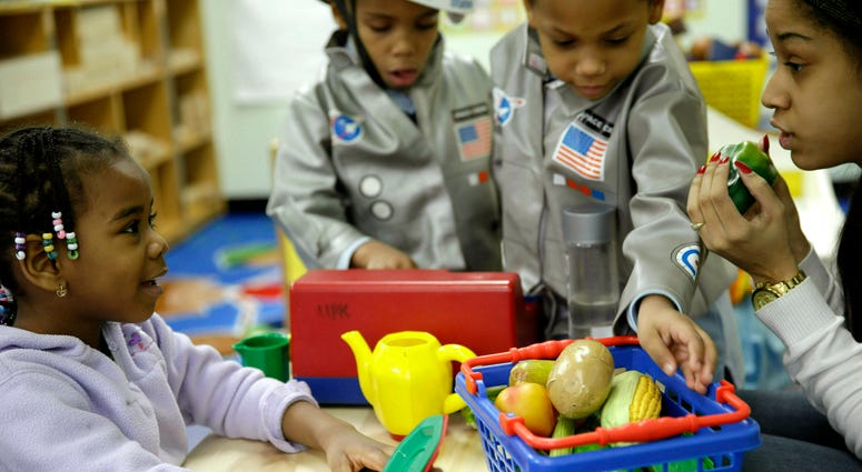 Oumou Balde, 4, left, plays with her teacher in a pre-kindergarten class at the Sheltering Arms Learning Center in New York in a program that was produced in conjunction with "Sesame Street" to educate children about nutrition and health, Jan. 21, 2014. Early childhood education