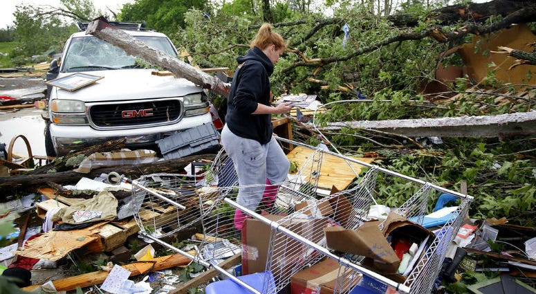Michelle Underwood searches through the wreckage of a feed store where she stored most of her belongings in Peggs, Okla., Tuesday, May 21, 2019. A tornado touched down near Tulsa International Airport amid storms in the Southern Plains that brought a deluge of rain and powerful winds, closing an interstate and flipping campers at a raceway.