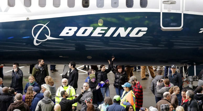 FILE- In this Feb. 5, 2018, file photo a Boeing 737 MAX 7, the newest version of Boeing's fastest-selling airplane, is displayed during a debut for employees and media of the new jet in Renton, Wash. Boeing says it's providing $100 million over several years to help families and communities affected by two crashes of its 737 Max plane that killed 346 people.