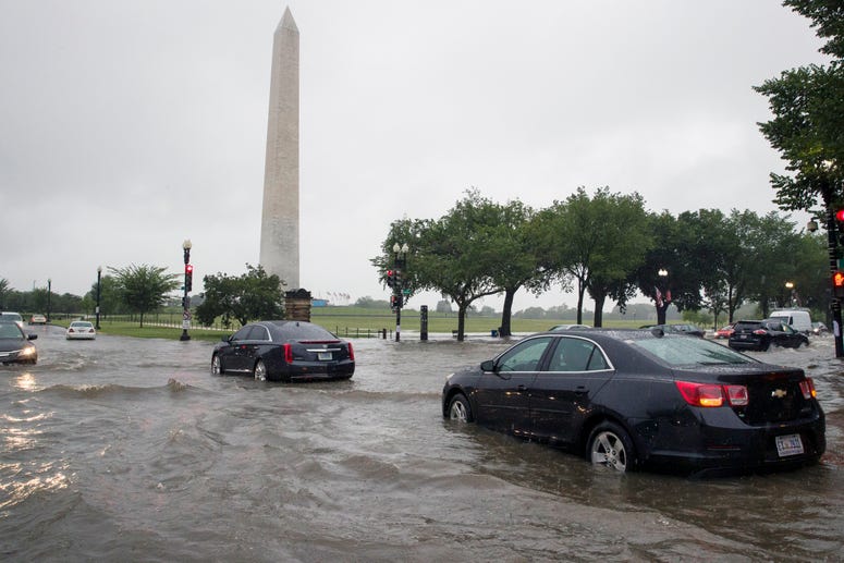 Heavy rainfall flooded the intersection of 15th Street and Constitution Ave., NW stalling cars in the street, Monday, July 8, 2019, in Washington near the Washington Monument. Flooding