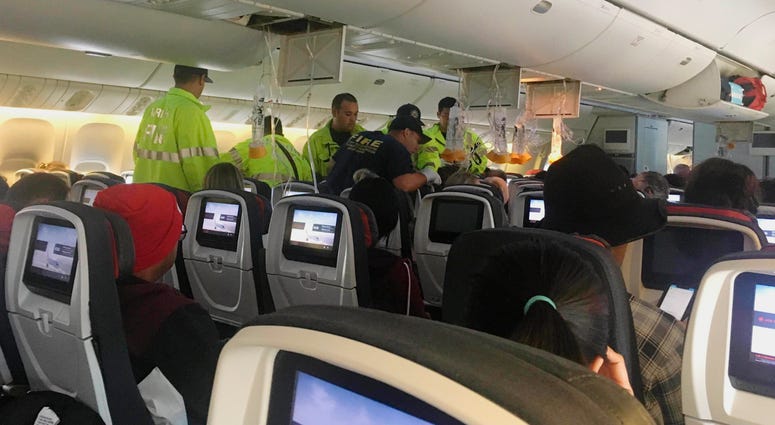 Responders treat a passenger on an Air Canada flight to Australia that was diverted and landed at Daniel K. Inouye International Airport in Honolulu on Thursday, July 11, 2019. Air Canada
