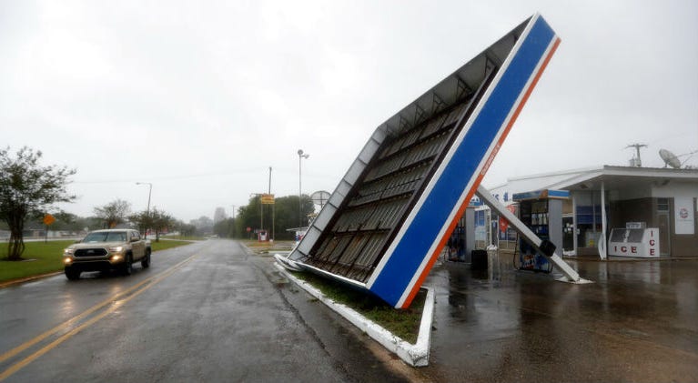 A vehicle passes a toppled gas pump canopy in Berwick, La., following a severe weather assault from Tropical Storm Barry, Saturday, July 13, 2019. Gulf Coast keeps guard up as Barry continues drenching