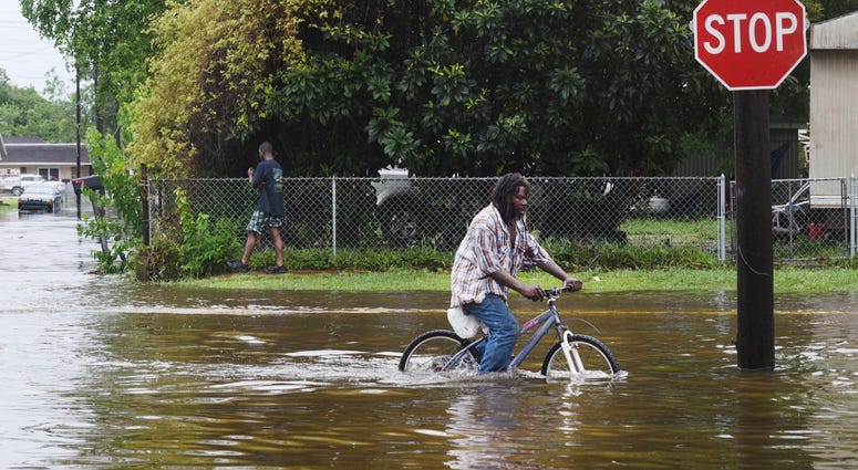 A man tries to bike through the flooding from the rains of storm Barry on LA Hwy 675 in New Iberia, La., Sunday, July 14, 2019. A man tries to bike through the flooding from the rains of storm Barry on LA Hwy 675 in New Iberia, La., Sunday, July 14, 2019.