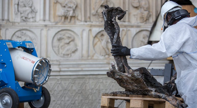 A worker cleans debris, during preliminary work to repair the fire damage at the Notre Dame de Paris Cathedral, in Paris, France, Wednesday, July 24, 2019. Notre Dame