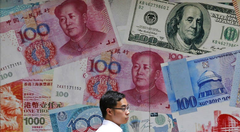 FILE - In this June 10, 2019, file photo, a man walks past a money exchange shop decorated with different banknotes at Central, a business district of Hong Kong. China's yuan fell below the politically sensitive level of seven to the U.S. dollar on Monday, Aug. 5, 2019, possibly adding to trade tension with Washington.