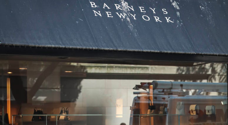 In this July 16, 2019, file photo a pedestrian reflect in a store window at Barneys department store in New York. In this July 16, 2019, file photo a pedestrian reflect in a store window at Barneys department store in New York.