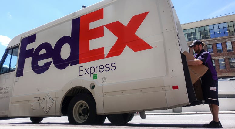 In this June 25, 2019, file photo a FedEx delivery truck is loaded by an employee on the street in downtown Cincinnati. FedEx