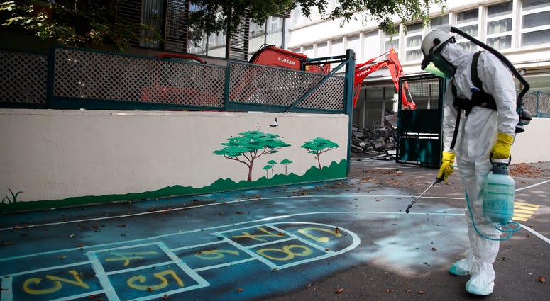 A worker sprays an adhesive product on the ground to gather up the lead particles in the school yard of Saint Benoit primary school in Paris, France, Thursday, Aug. 8, 2019. A worker sprays an adhesive product on the ground to gather up the lead particles in the school yard of Saint Benoit primary school in Paris, France, Thursday, Aug. 8, 2019.