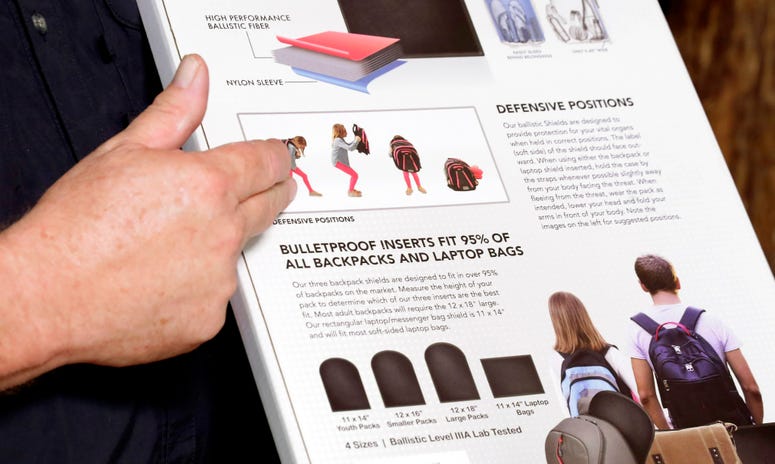 Steve Naremore, founder and CEO of TuffyPacks, notes the use and various options of his bulletproof inserts on the packaging of the product that can be placed into various makes and sizes of backpacks, during a demonstration at the Shiloh Shooting Range. Bullet-resistant backpacks