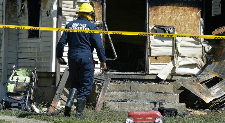 Erie Bureau of Fire Inspector Mark Polanski helps investigate a fatal fire at 1248 West 11th St. in Erie, Pa, on Sunday, Aug. 11, 2019. Authorities say an early morning fire in northwestern Pennsylvania claimed the lives of multiple children and sent another person to the hospital.