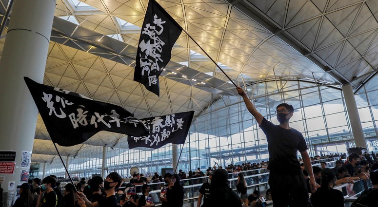 Protesters wave flags at the Hong Kong International Airport, Monday, Aug. 12, 2019. One of the world's busiest airports canceled all flights after thousands of Hong Kong pro-democracy protesters crowded into the main terminal Monday afternoon. Protesters wave flags at the Hong Kong International Airport, Monday, Aug. 12, 2019. One of the world's busiest airports canceled all flights after thousands of Hong Kong pro-democracy protesters crowded into the main terminal Monday afternoon.