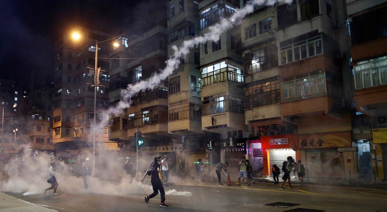 Protesters react to tear gas from Shum Shui Po police station in Hong Kong on Wednesday, Aug. 14, 2019. Protesters react to tear gas from Shum Shui Po police station in Hong Kong on Wednesday, Aug. 14, 2019.