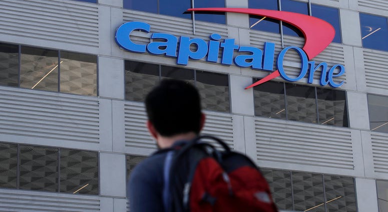In this July 16, 2019, file photo, a man walks across the street from a Capital One location in San Francisco. Capital One