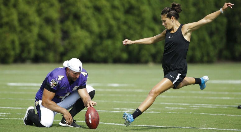 Baltimore Ravens' Sam Koch holds the ball for United States soccer player Carli Lloyd as she attempts to kick a field goal after the Philadelphia Eagles and the Baltimore Ravens held a joint NFL football practice in Philadelphia, Tuesday, Aug. 20, 2019. Baltimore Ravens' Sam Koch holds the ball for United States soccer player Carli Lloyd as she attempts to kick a field goal after the Philadelphia Eagles and the Baltimore Ravens held a joint NFL football practice in Philadelphia, Tuesday, Aug. 20, 2019.