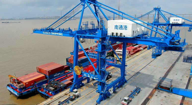 In this July 18, 2019, file photo, shipping containers are loaded onto a cargo ship at a port in Nantong in eastern China's Jiangsu province. Cargo ship