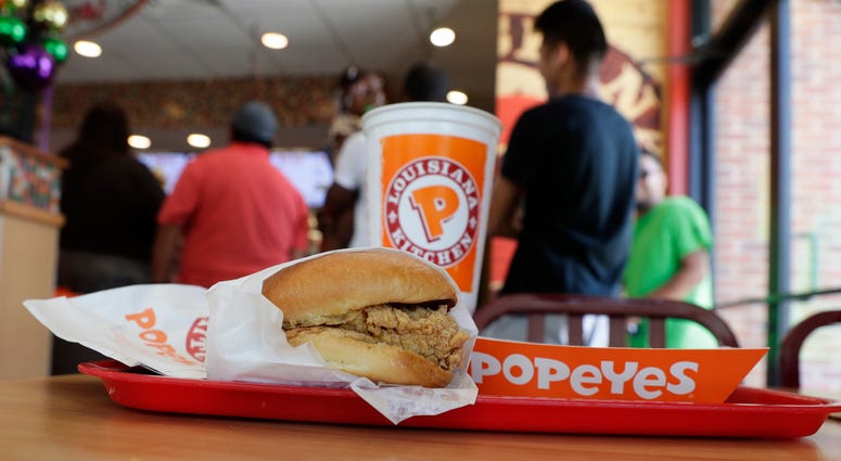 A chicken sandwich sits on a table at a Popeyes as guests wait in line, Thursday, Aug. 22, 2019, in Kyle, Texas. Popeyes chicken sandwich