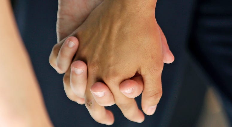 In this Wednesday, July 15, 2015 file photo, a lesbian couple holds hands in Salt Lake City. In this Wednesday, July 15, 2015 file photo, a lesbian couple holds hands in Salt Lake City.