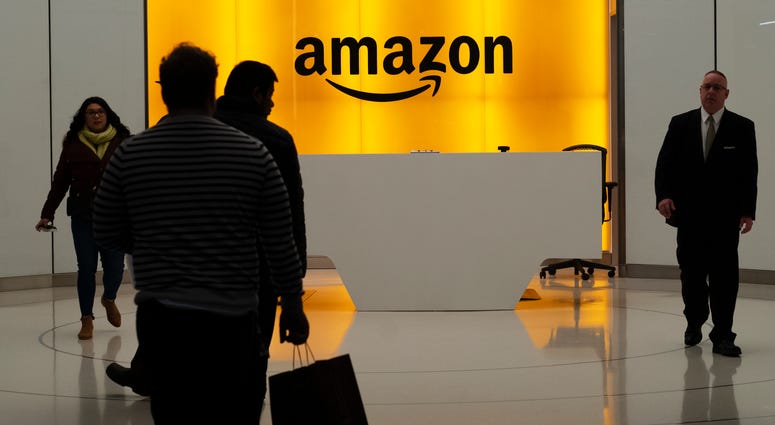 In this Feb. 14, 2019, file photo people walk into the lobby for Amazon offices in New York. In this Feb. 14, 2019, file photo people walk into the lobby for Amazon offices in New York.