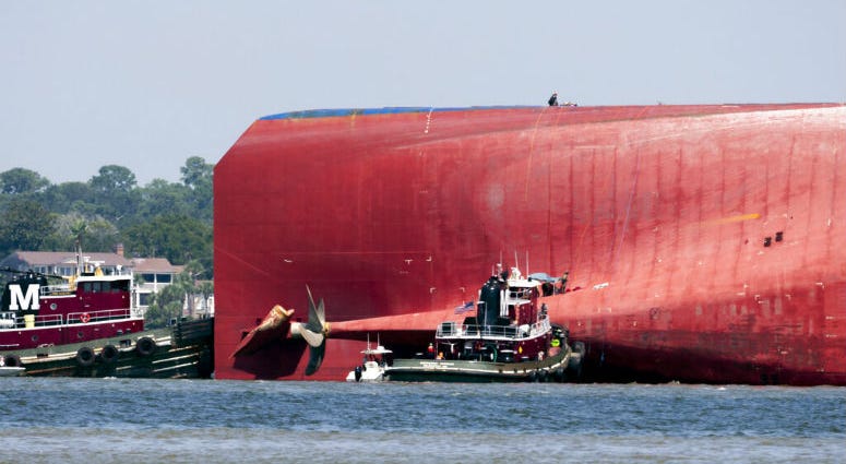 Rescuers work near the stern of the vessel Golden Ray as it lays on its side near the Moran tug boat Dorothy Moran, Monday, Sept. 9, 2019, in Jekyll Island, Ga. Rescuers work near the stern of the vessel Golden Ray as it lays on its side near the Moran tug boat Dorothy Moran.