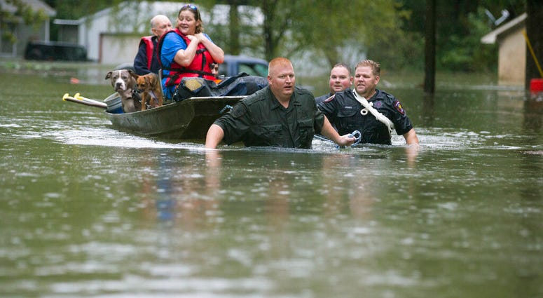 Splendora Police Lt. Troy Teller, left, Cpl. Jacob Rutherford and Mike Jones pull a boat carrying Anita McFadden and Fred Stewart from their flooded neighborhood inundated by rain from Tropical Depression Imelda on Thursday, Sept. 19, 2019, in Spendora, T Splendora Police Lt. Troy Teller, left, Cpl. Jacob Rutherford and Mike Jones pull a boat carrying Anita McFadden and Fred Stewart from their flooded neighborhood inundated by rain from Tropical Depression Imelda.