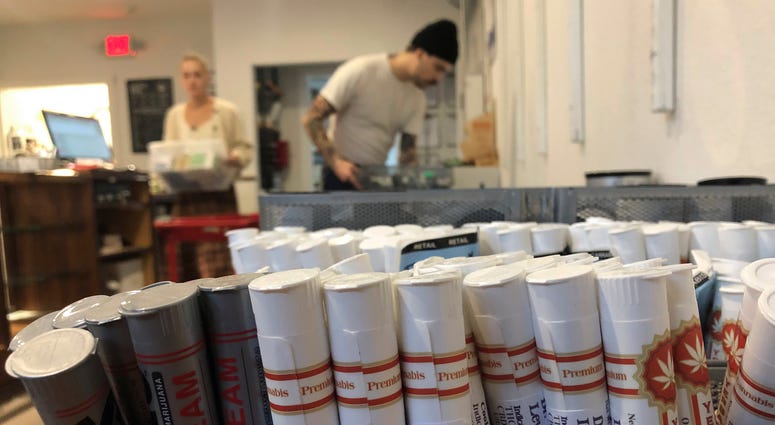 Employees at the marijuana retailer Bridge City Collective in Portland, Ore., can be seen setting up the store for the day behind a row of marijuana products for sale there. Employees at the marijuana retailer Bridge City Collective in Portland, Ore., can be seen setting up the store for the day behind a row of marijuana products for sale there.