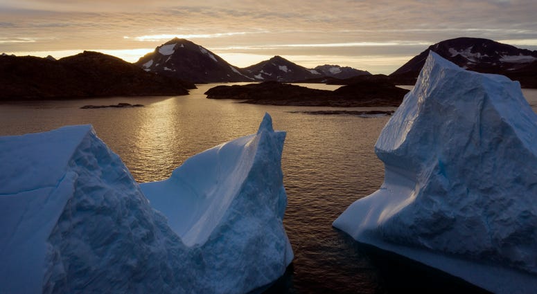A special UN-affiliated report released on Wednesday, Sept. 24, 2019 projects three feet of rising seas by the end of the century, much fewer fish, weakening ocean currents, even less snow and ice, and nastier hurricanes, caused by climate change. File photo shows an aerial view of large icebergs floating as the sun rises near Kulusuk, Greenland.