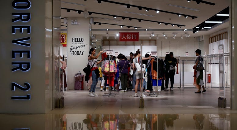 Low-price fashion chain Forever 21, a one-time hot destination for teen shoppers that fell victim of its own rapid expansion and changing consumer tastes, announced Sunday, Sept. 29, 2019, that it has filed for Chapter 11 bankruptcy protection. Women select clothing at an American fast fashion retailer Forever 21 which is offering clearance discounts at a shopping mall after it pulled out from China's market, in Beijing.