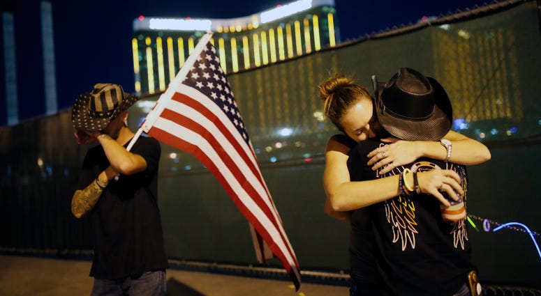 Megan Murphy, right in hat, embraces Cara Knoedler as Kenneth Wright wipes his eyes on the first anniversary of the mass shooting in Las Vegas. Megan Murphy, right in hat, embraces Cara Knoedler as Kenneth Wright wipes his eyes on the first anniversary of the mass shooting in Las Vegas.