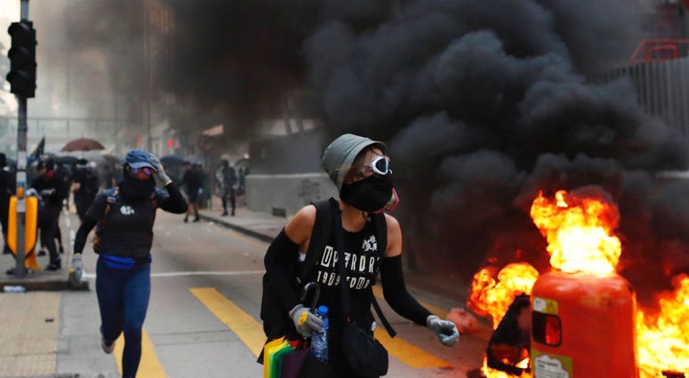Protesters take cover in Hong Kong, Tuesday, Oct. 1, 2019. A Hong Kong police official says a pro-democracy protester was shot when an officer opened fire with his revolver during clashes Tuesday. Protesters take cover in Hong Kong, Tuesday, Oct. 1, 2019. A Hong Kong police official says a pro-democracy protester was shot when an officer opened fire with his revolver during clashes Tuesday.