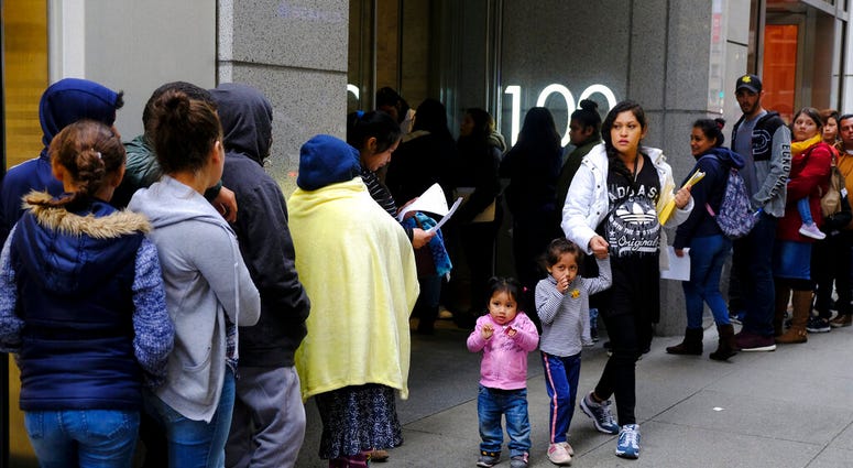 Hundreds of people overflow onto the sidewalk in a line snaking around the block outside a U.S. immigration office with numerous courtrooms in San Francisco. Hundreds of people overflow onto the sidewalk in a line snaking around the block outside a U.S. immigration office with numerous courtrooms in San Francisco.