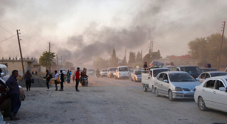 Syrians flee shelling by Turkish forces in Ras al Ayn, northeast Syria, Wednesday, Oct. 9, 2019. Syrians flee shelling by Turkish forces in Ras al Ayn, northeast Syria.
