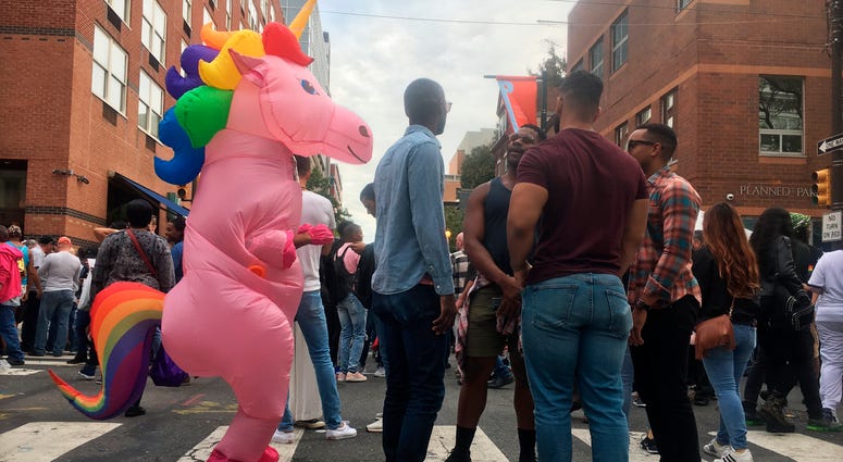 A person in a unicorn costume walks among others in attendance at Philadelphia OutFest, Sunday, Oct. 13, 2019, in Philadelphia. OutFest