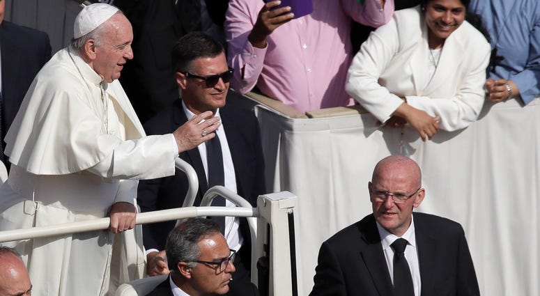Vatican head of security Domenico Giani, right, flanks Pope Francis' pope mobile at the end of a canonization Mass in St. Peter's Square at the Vatican, Sunday, Oct. 13, 2019. Vatican head of security Domenico Giani, right, with the pope.