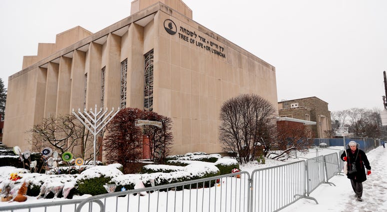 Leaders of the Tree of Life synagogue, where worshippers were fatally shot last year, want to rebuild and renovate the building, turning it into what they hope will be a symbol against hatred. A woman passes by the Tree of Life Synagogue in Pittsburgh's Squirrel Hill neighborhood.