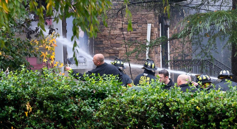 Woodbridge firefighters work to extinguish the scene of a plane crash at a home in Woodbridge, N.J., Tuesday, Oct. 29, 2019. Plane crash