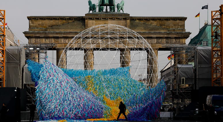 The skynet artwork 'Visions In Motion' is set to overhang the 'Strasse des 17. Juni' (Street of June 17) boulevard in front of the Brandenburg Gate in Berlin, Germany, Friday, Nov. 1, 2019. The skynet artwork 'Visions In Motion' is set to overhang the 'Strasse des 17. Juni' (Street of June 17) boulevard in front of the Brandenburg Gate in Berlin, Germany, Friday, Nov. 1, 2019.