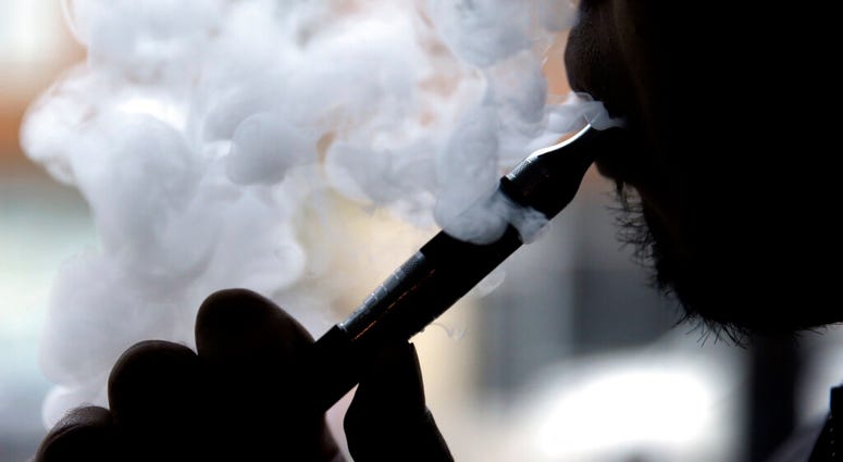 A a man smokes an electronic cigarette in Chicago. A man smokes an electronic cigarette in Chicago.