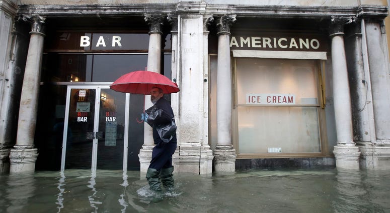 A man walks past a closed cafe in a flooded Venice, Italy, Tuesday, Nov. 12, 2019. A man walks past a closed cafe in a flooded Venice, Italy, Tuesday, Nov. 12, 2019.