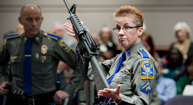 In this Jan. 28, 2013, file photo, firearms training unit Detective Barbara J. Mattson, of the Connecticut State Police, holds up a Bushmaster AR-15 rifle, the same gun used by Adam Lanza in the Sandy Hook School shooting, for a demonstration. Gun demonstration